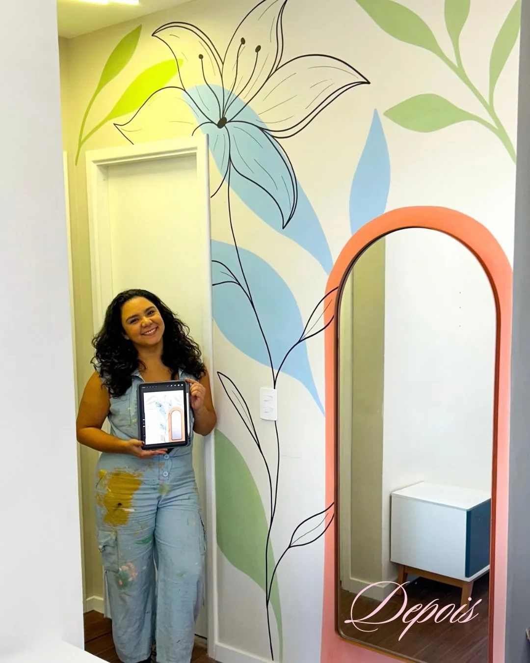 A mesma parede e espelho com pintura floral em verde, azul e coral